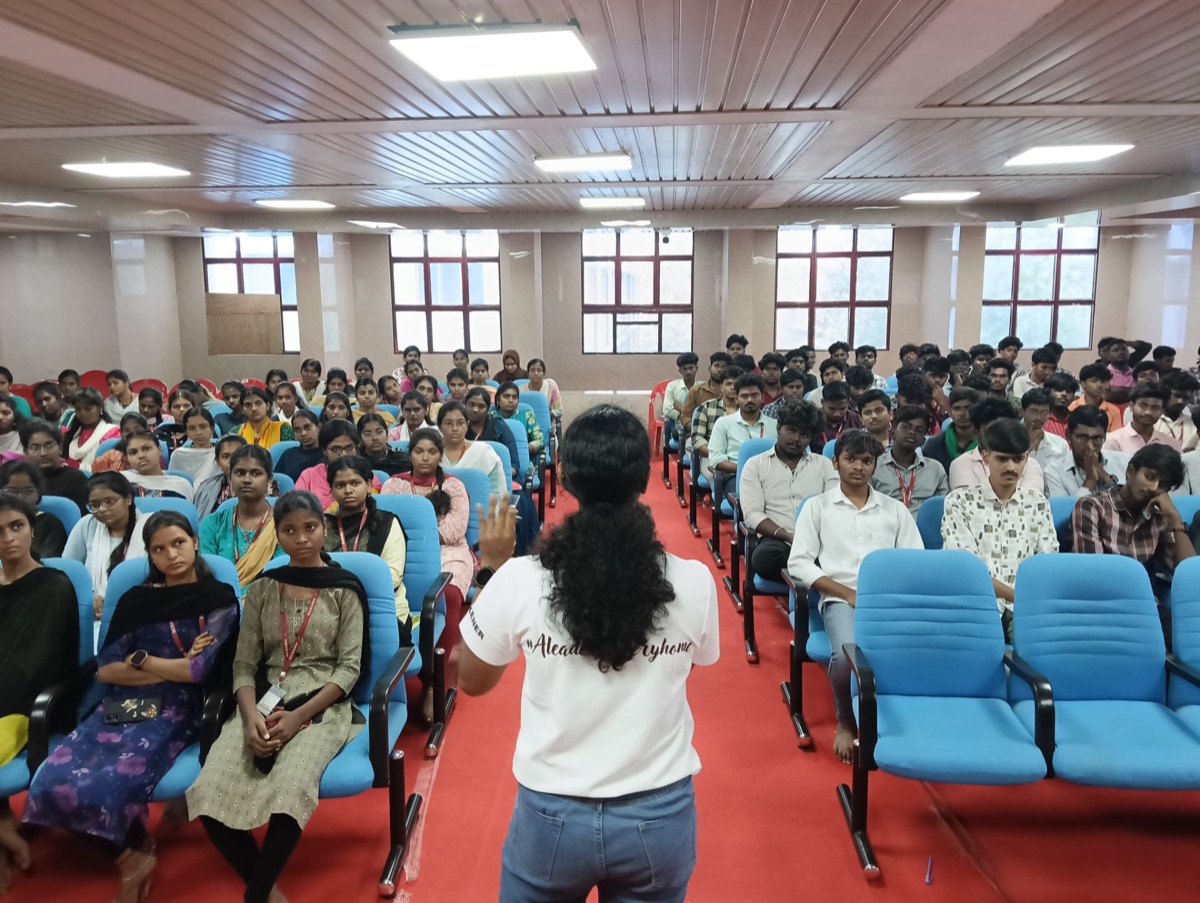 A student addressing a hall full of her classmates